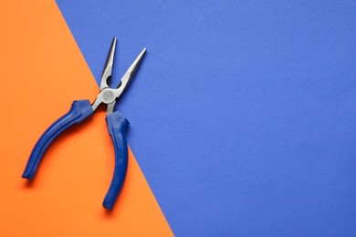 Photo of Needle nose pliers on color background, top view. Space for text