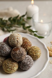 Photo of Different delicious vegan candy balls on light grey marble table