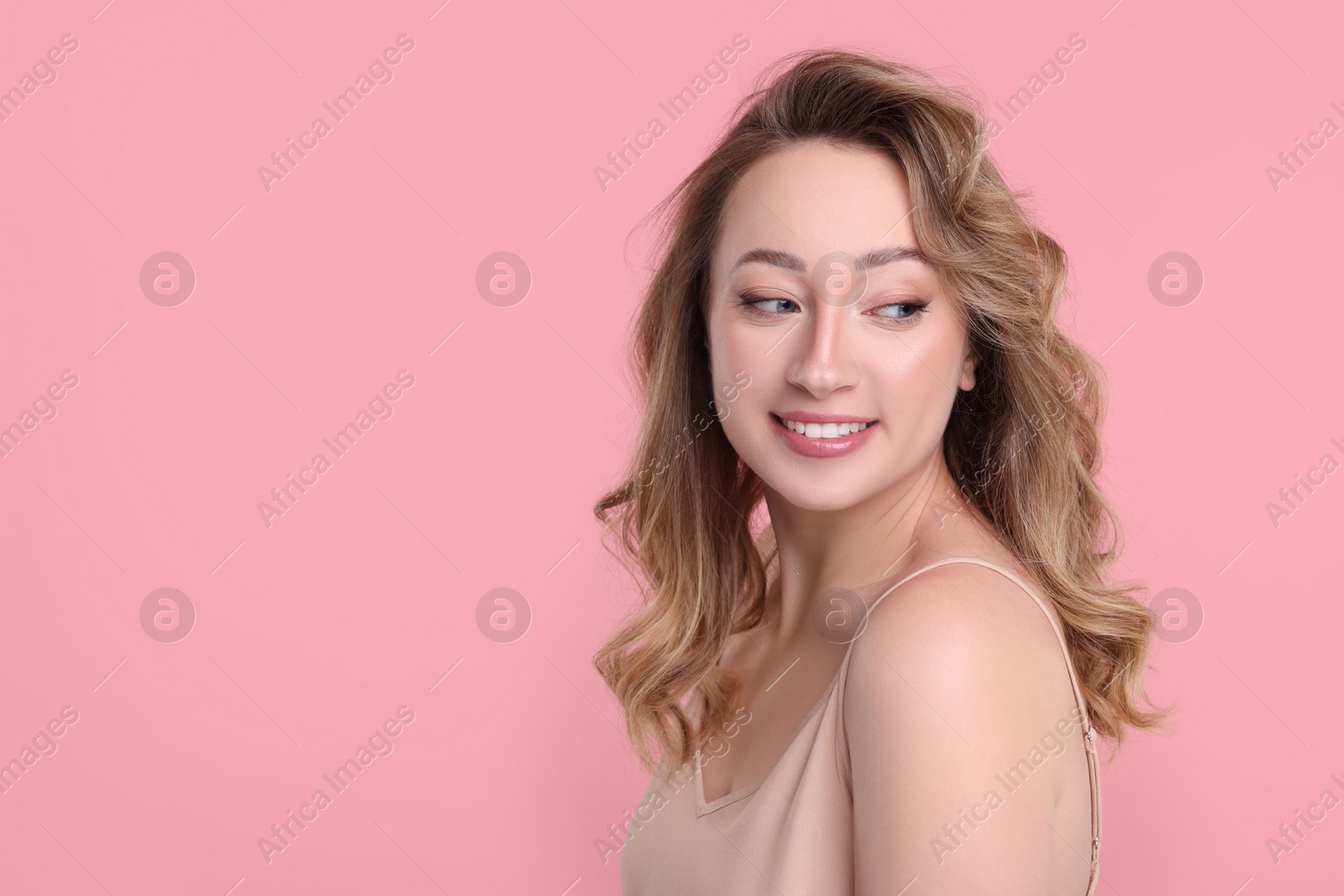 Photo of Portrait of smiling woman on pink background. Space for text