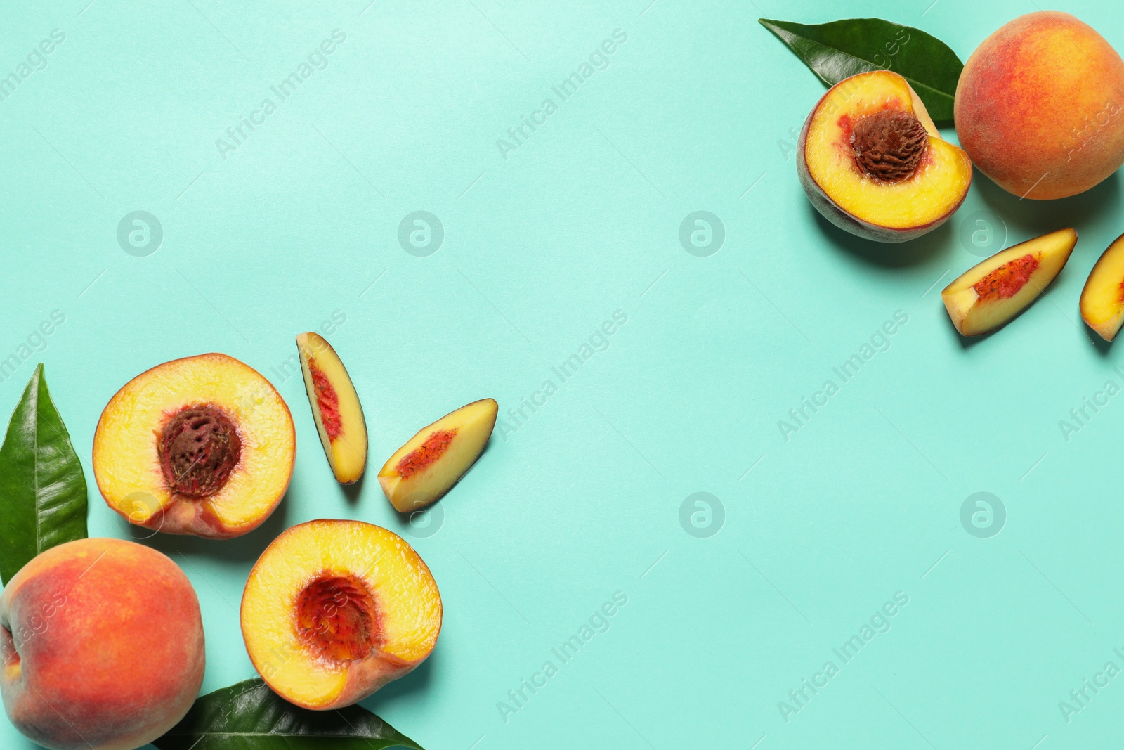 Photo of Cut and whole fresh ripe peaches with green leaves on light blue background, flat lay. Space for text