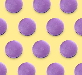 Image of Delicious macarons on yellow background, flat lay 