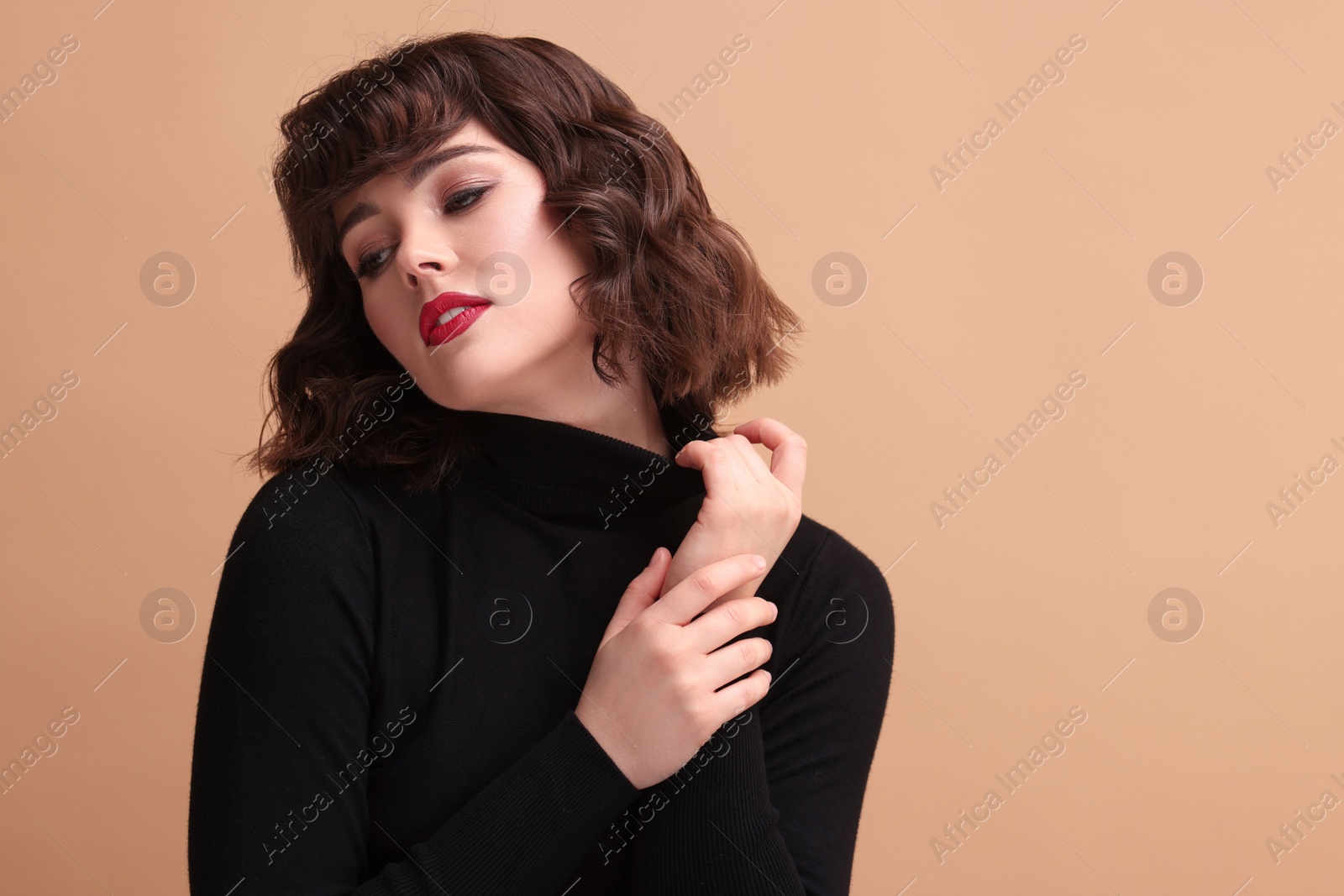 Photo of Portrait of beautiful young woman with wavy hairstyle on beige background. Space for text