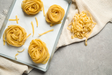 Photo of Tagliatelle pasta on light table, flat lay