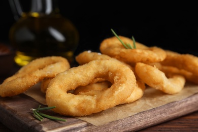 Photo of Fried onion rings served on wooden table, closeup