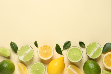 Photo of Fresh ripe lemons, limes and green leaves on beige background, flat lay. Space for text