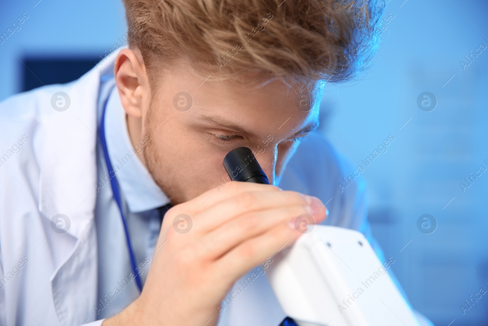 Photo of Male scientist using modern microscope in chemistry laboratory