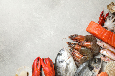 Fresh fish and seafood on marble table, flat lay. Space for text