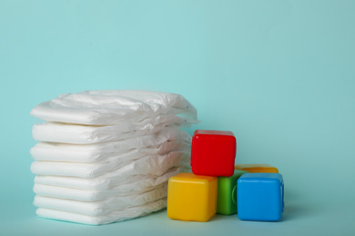 Photo of Diapers and plastic cubes on light blue background