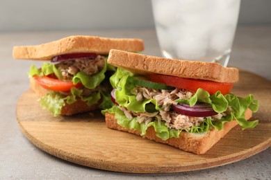 Delicious sandwiches with tuna and vegetables on light grey table