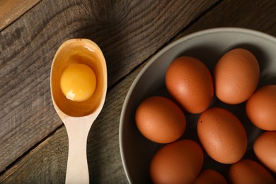 Photo of Raw chicken eggs on wooden table, flat lay