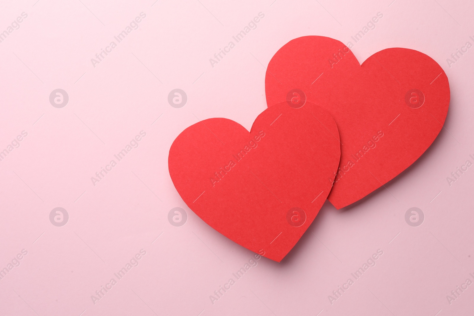 Photo of Paper hearts on pink background, top view. Space for text