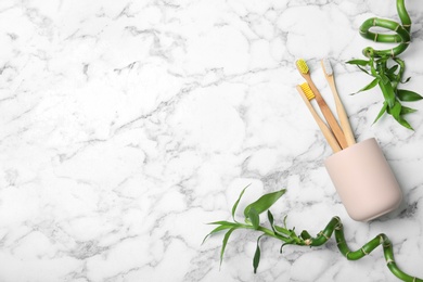 Photo of Flat lay composition with bamboo toothbrushes and space for text on marble background