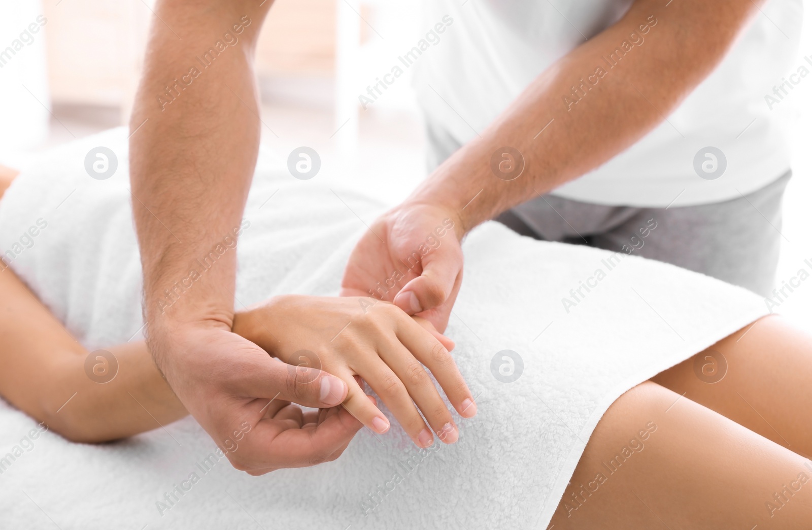 Photo of Young woman receiving massage in salon, closeup