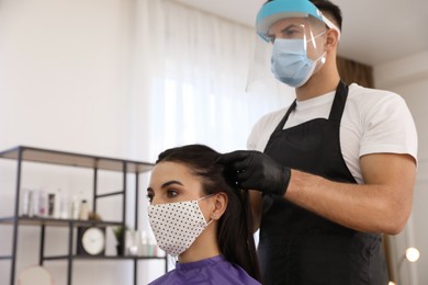 Professional stylist working with client in salon. Hairdressing services during Coronavirus quarantine