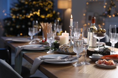 Photo of Christmas table setting with festive decor and dishware indoors