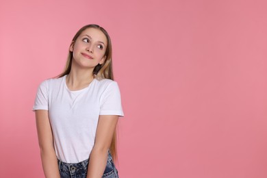 Portrait of beautiful teenage girl on pink background. Space for text