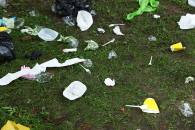 Photo of Different garbage scattered on green grass outdoors