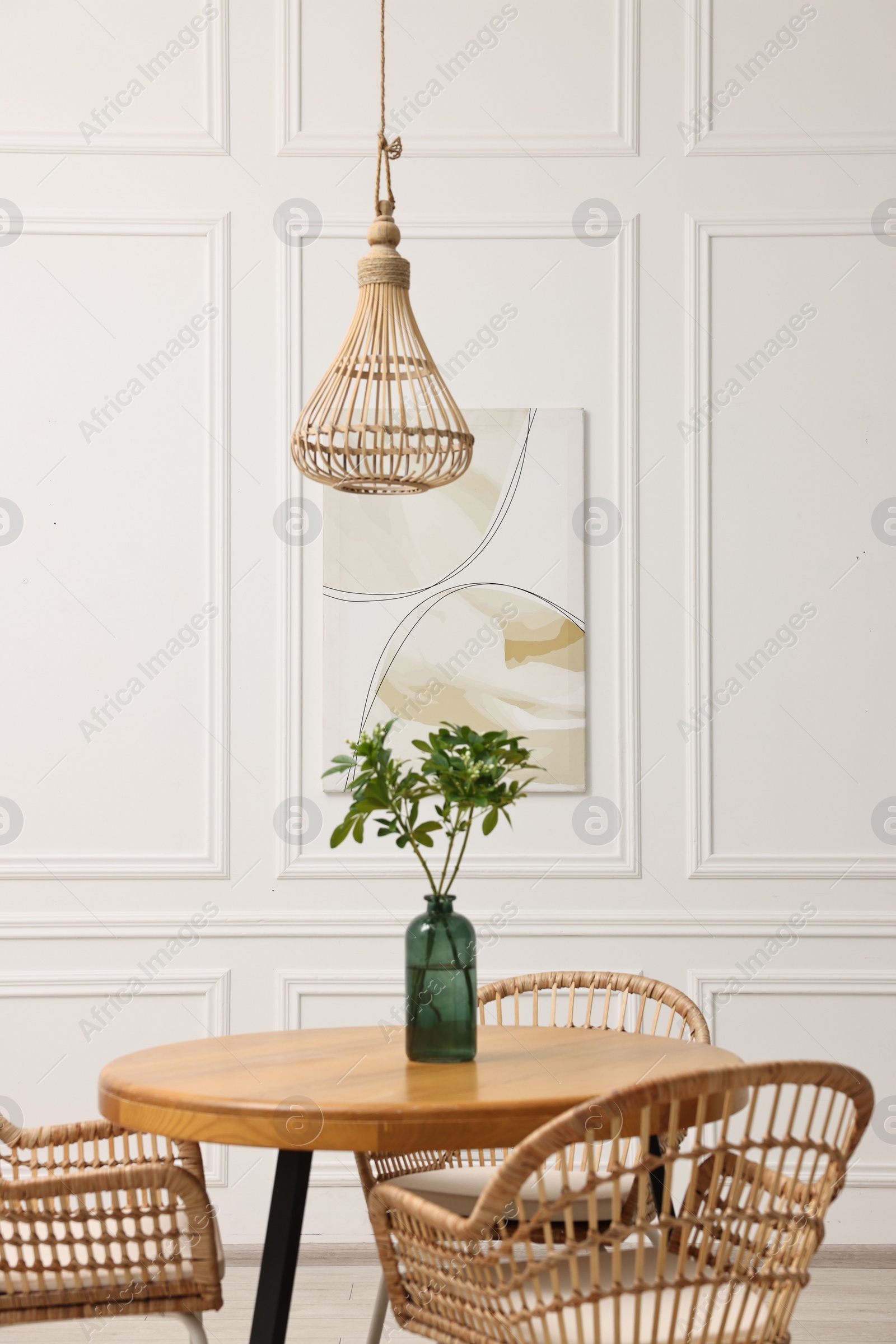 Photo of Dining room interior with comfortable furniture and green branches