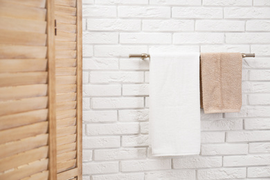 Photo of Fresh clean towels on hanger in bathroom