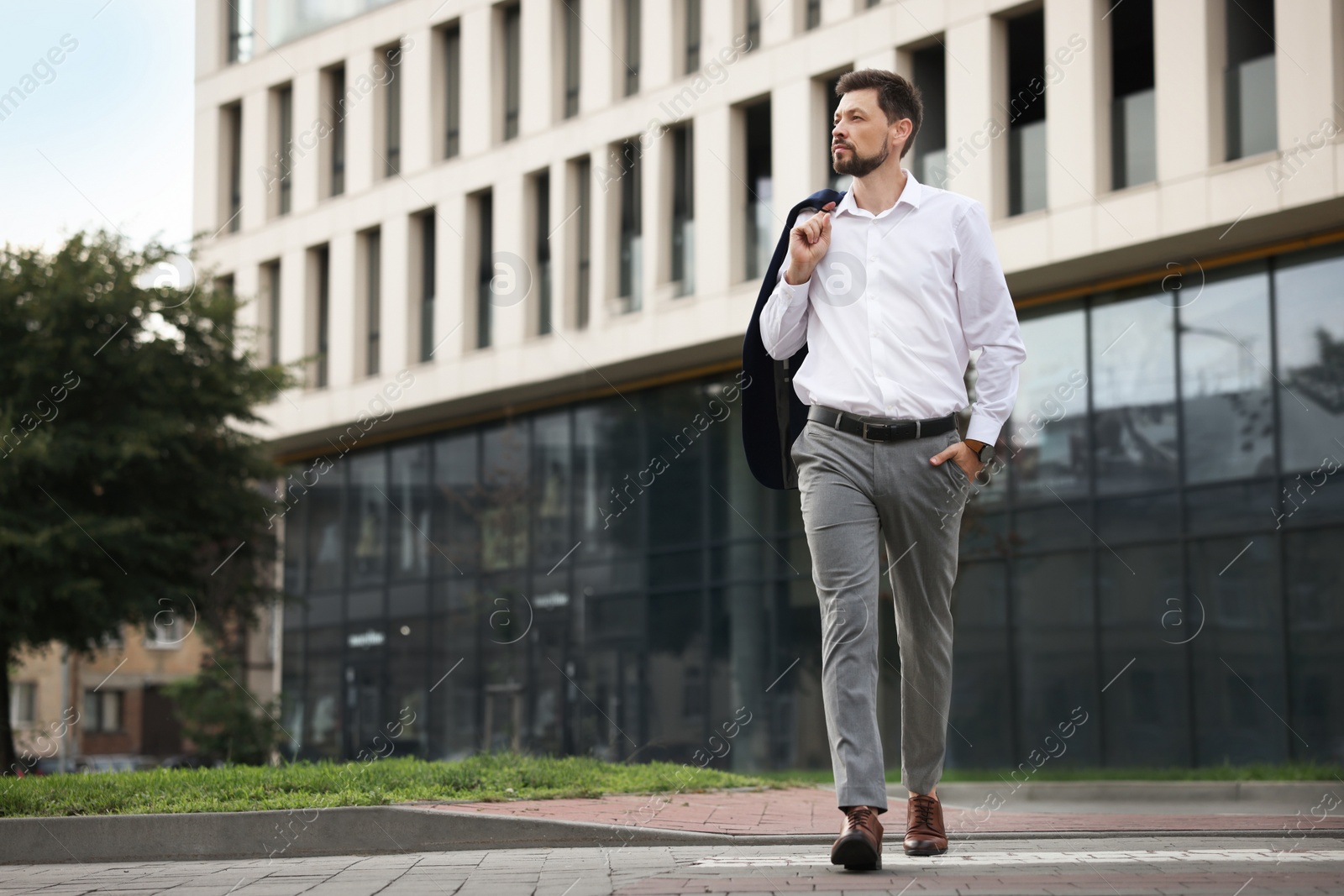 Photo of Handsome bearded businessman walking on city street