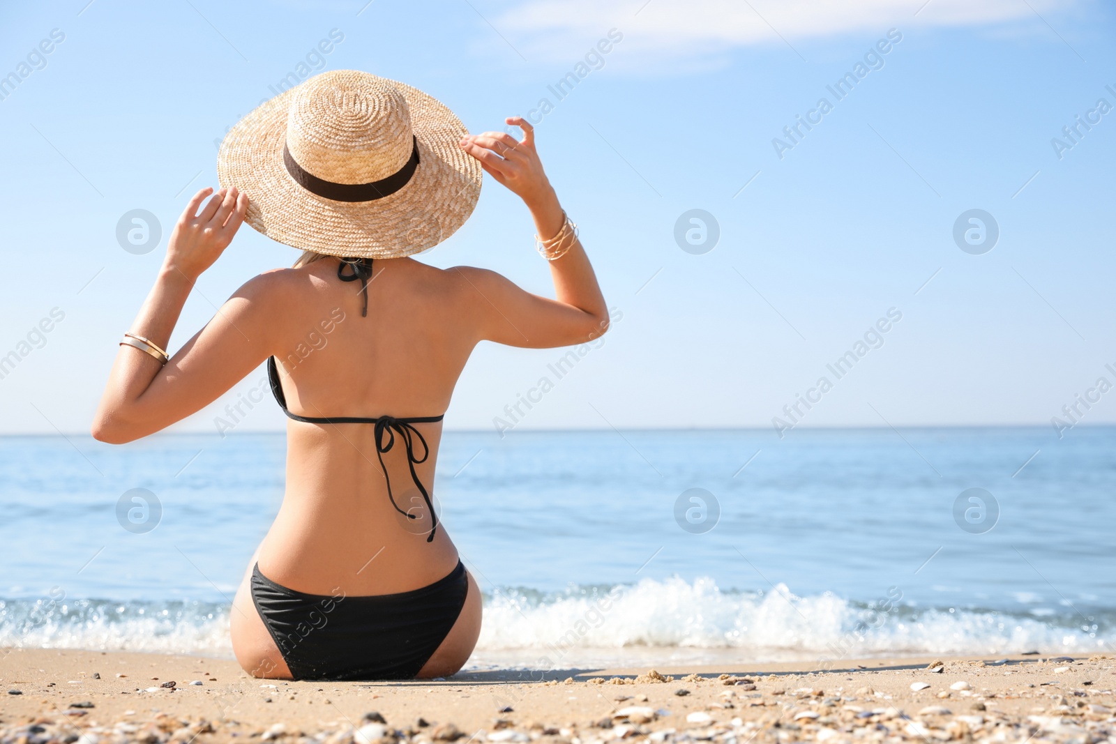 Photo of Young woman with beautiful body on sandy beach. Space for text