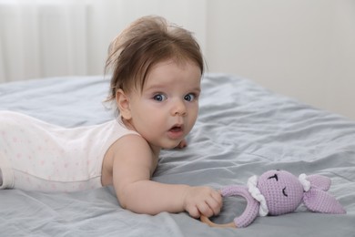 Photo of Cute little baby with toy on bed indoors. Space for text