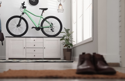 Photo of Hallway interior with stylish furniture and green bicycle