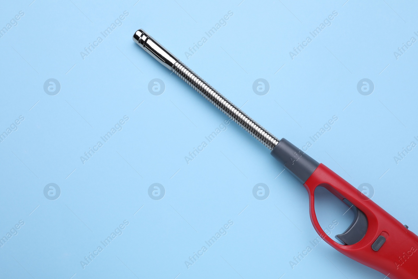 Photo of One gas lighter on light blue background, top view. Space for text