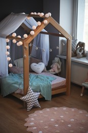 Stylish child room interior with house bed and different toys