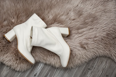 Photo of Pair of stylish leather shoes on faux fur, flat lay. Space for text