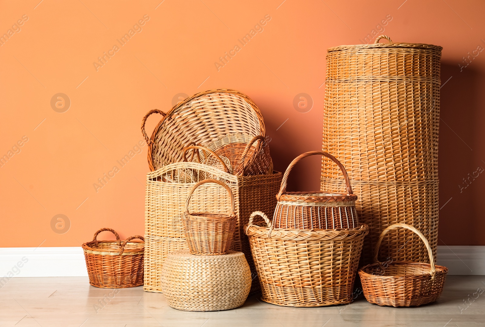 Photo of Many different wicker baskets on floor near coral wall