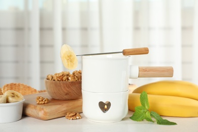 Photo of Fondue pot and products on table indoors