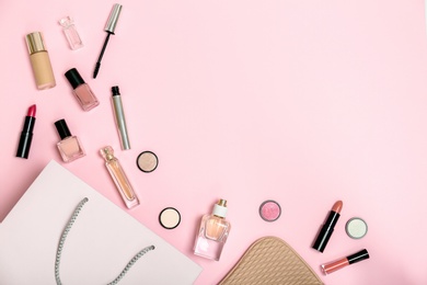 Flat lay composition with shopping bag and cosmetics on color background