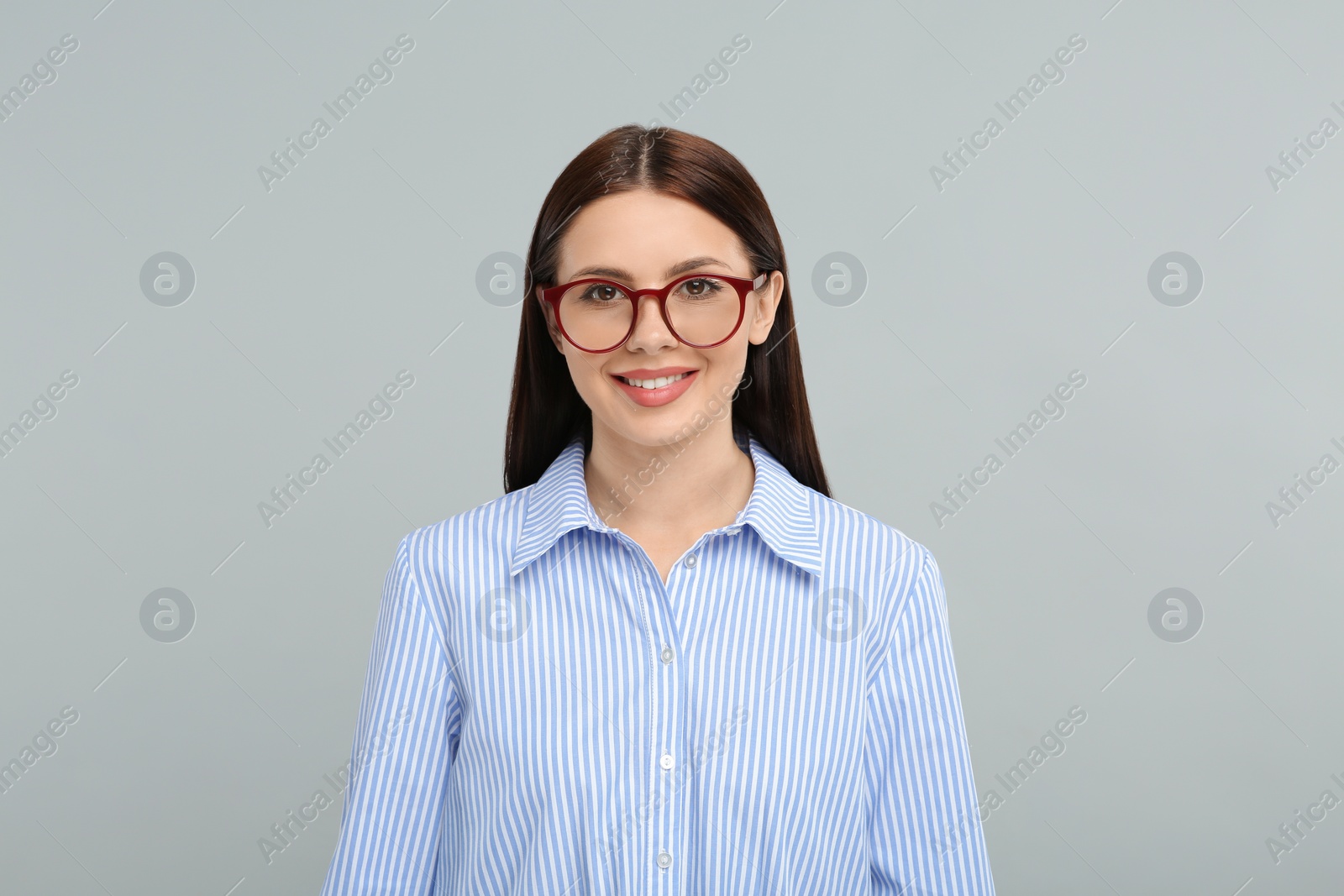 Photo of Portrait of smiling woman in stylish eyeglasses on grey background