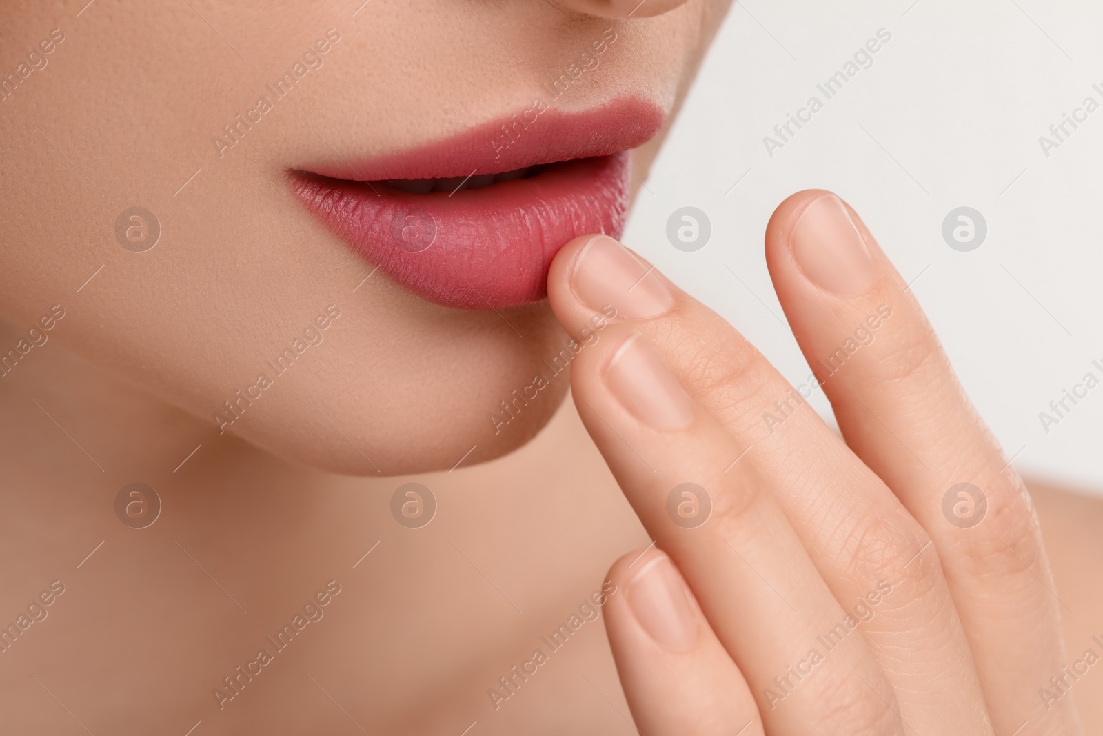 Photo of Young woman with beautiful full lips on white background, closeup