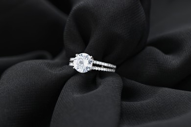 Beautiful ring with gemstones on black fabric. Luxury jewelry