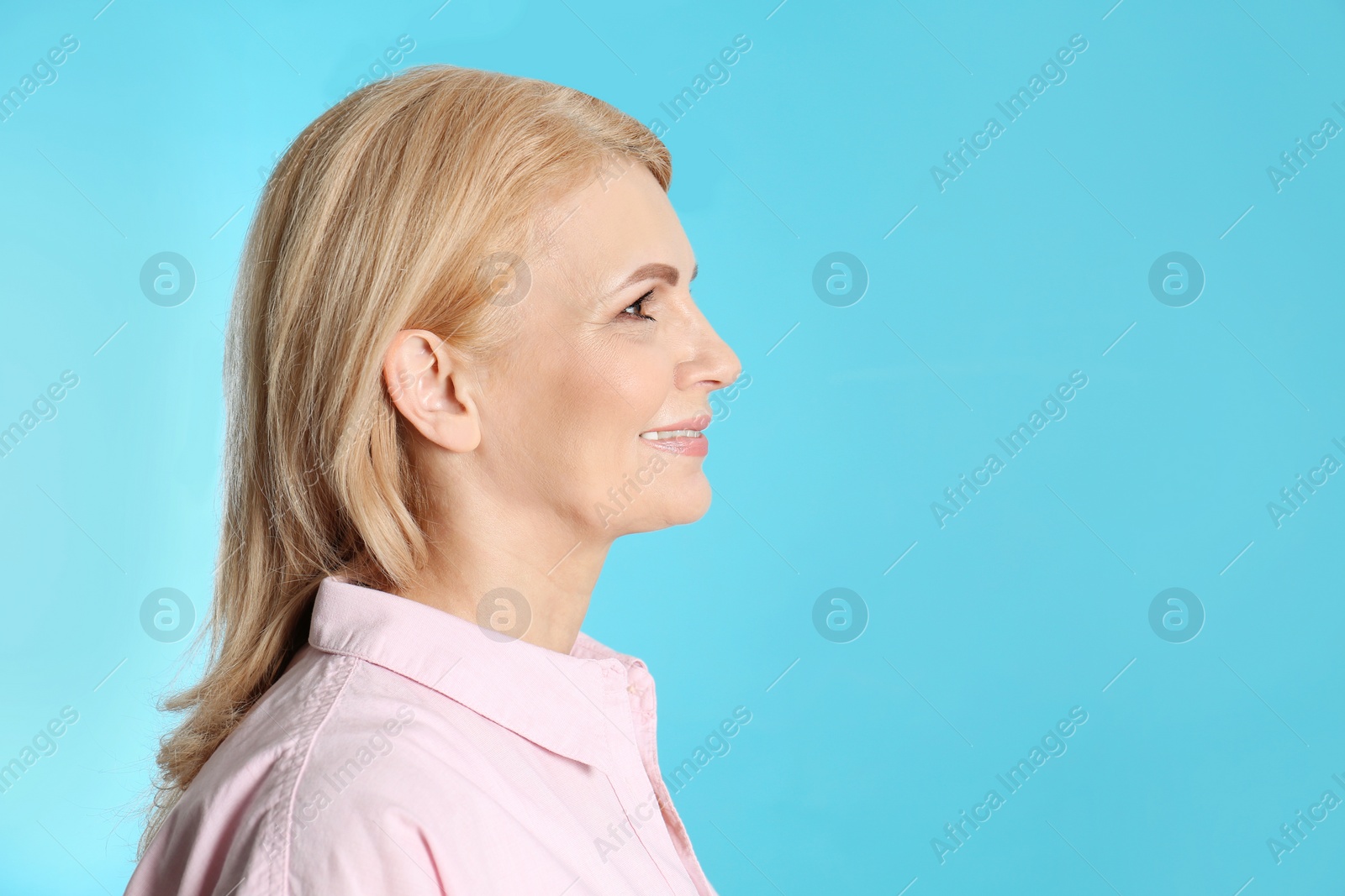Photo of Portrait of mature woman with beautiful face on blue background. Space for text