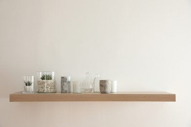 Photo of Wooden shelf with plants and decorative elements on light wall