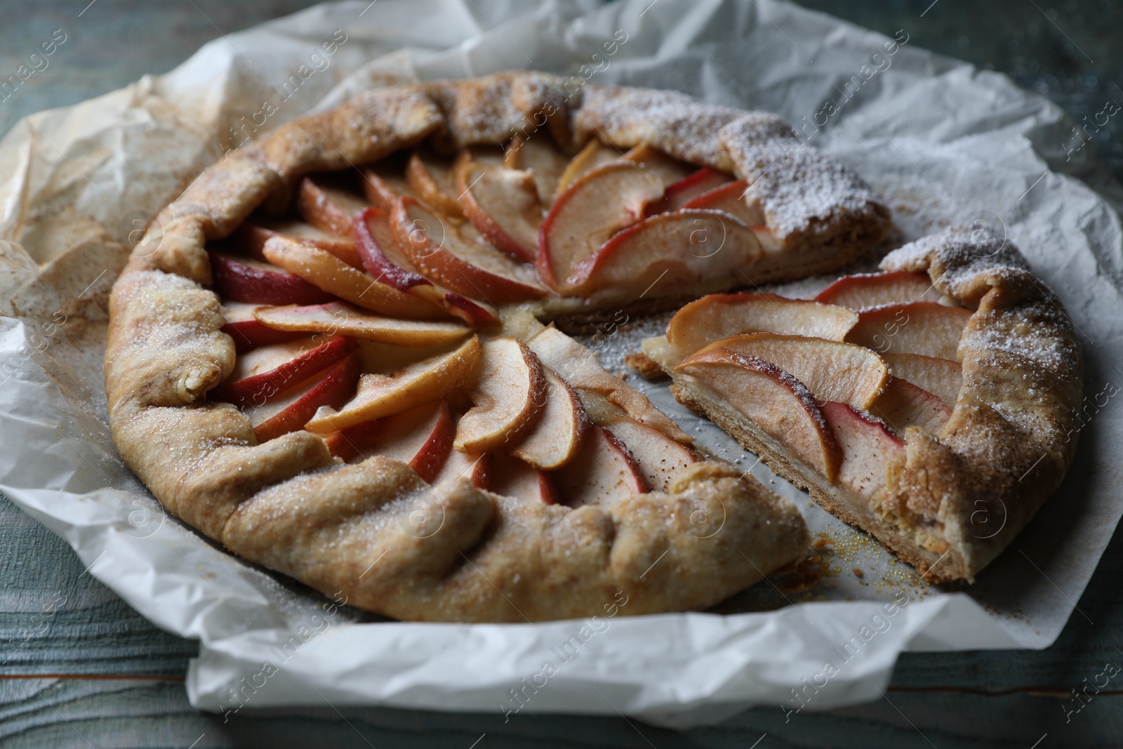 Photo of Delicious apple galette on wooden table, closeup