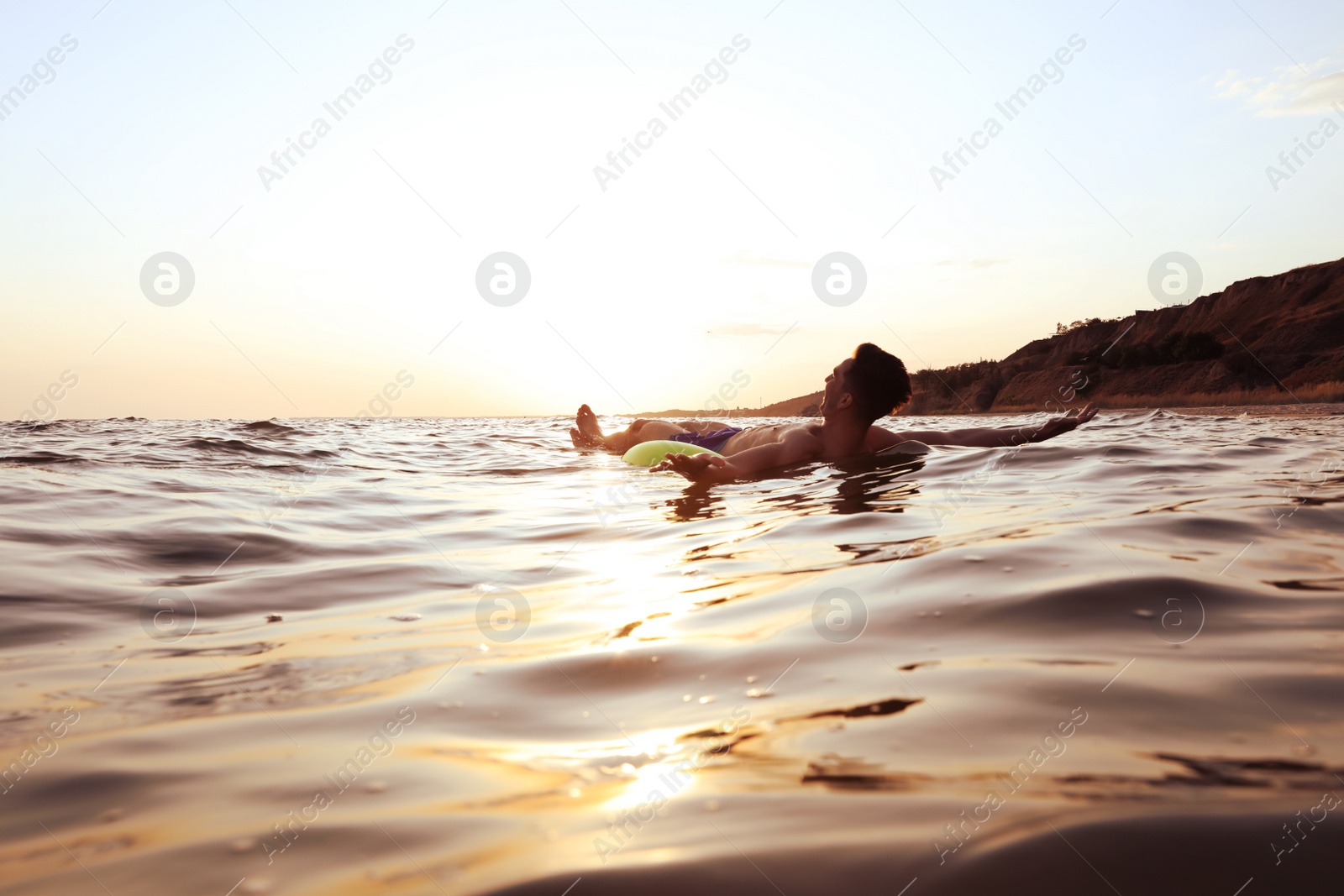 Photo of Young man with inflatable ring in sea