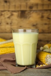 Photo of Freshly made corn milk in glass on wooden table