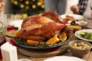 Photo of Festive dinner with baked turkey on table, closeup. Family Christmas celebration