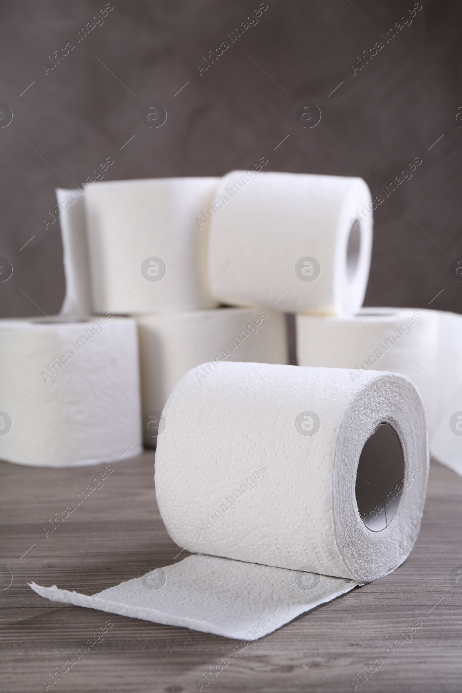 Photo of Soft toilet paper rolls on wooden table