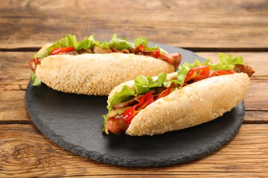 Photo of Tasty hot dogs on wooden table. Fast food