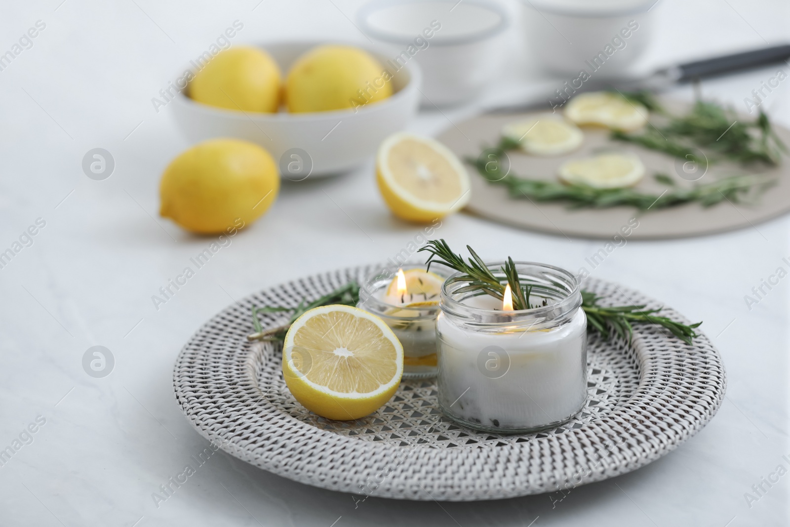 Photo of Natural homemade mosquito repellent candle and ingredients on white table