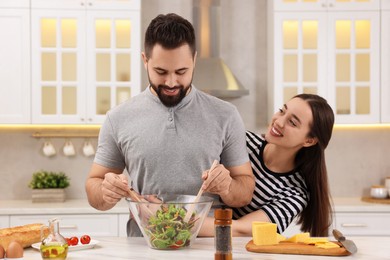 Photo of Lovely young couple cooking together in kitchen