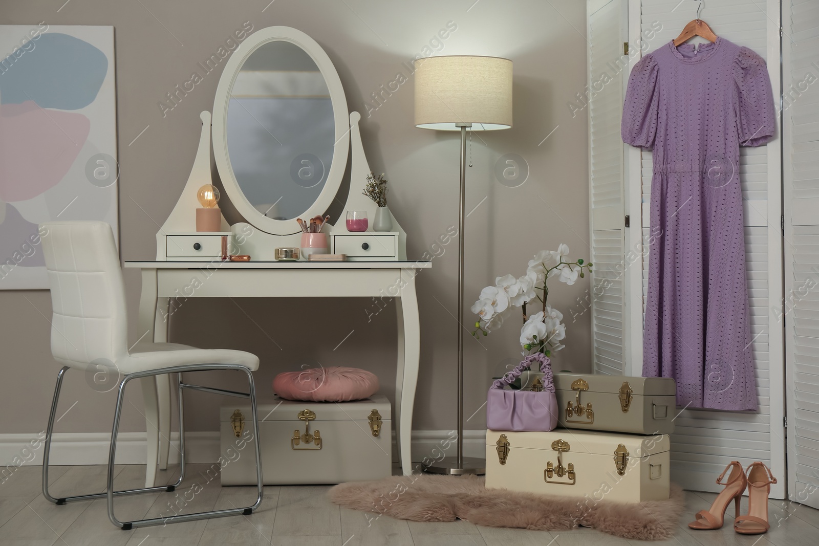 Photo of Stylish storage trunks, dressing table and beautiful orchid flower in room. Interior design