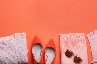 Photo of Flat lay composition with warm clothes on coral background. Space for text