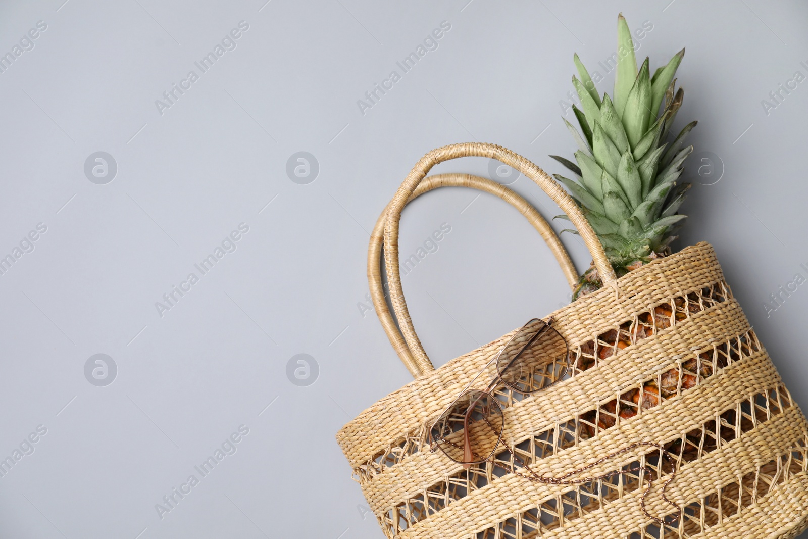 Photo of Stylish straw bag and sunglasses on grey background, flat lay with space for text. Summer accessories
