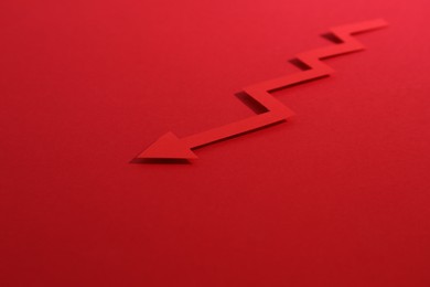 One zigzag paper arrow on red background, closeup. Space for text